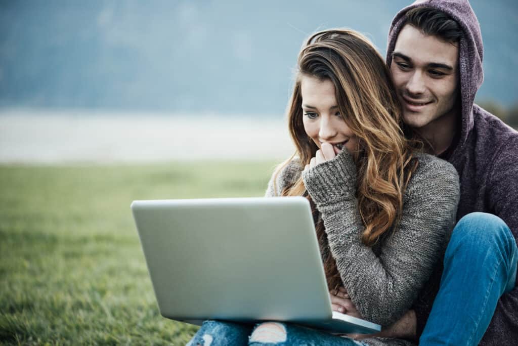 Couple with a laptop in nature wondering: should I start a blog?